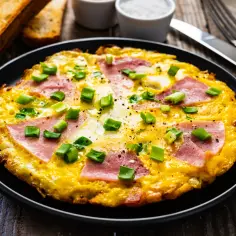 Pyszny omlet na słono z szynką i szczypiorkiem, idealny na śniadanie.