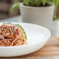 Pyszne spaghetti z sosem ragu, posypane parmezanem. Idealny przepis na obiad.