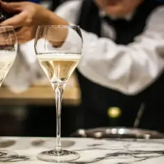Kelner nalewa musujące prosecco do kieliszków. To włoskie wino, idealne na toast.