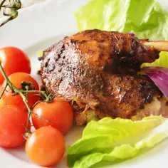 Najlepsza kaczka pieczona w rękawie, soczysta i aromatyczna, podana z pomidorkami, pomarańczą i sałatą.