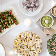 Szybkie danie na gorąco dla gości: kolorowe koreczki, roladki z łososiem i szpinakiem, tortille z kukurydzą, guacamole i hummus.