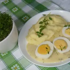 Pyszne puree ziemniaczane z jajkami w sosie chrzanowym na ciepło, ozdobione świeżym tymiankiem.