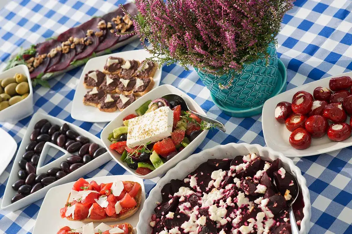 Pyszne greckie dania: sałatka grecka, oliwki, bruschetta z pomidorami, pieczone buraki z fetą i faszerowane papryczki.