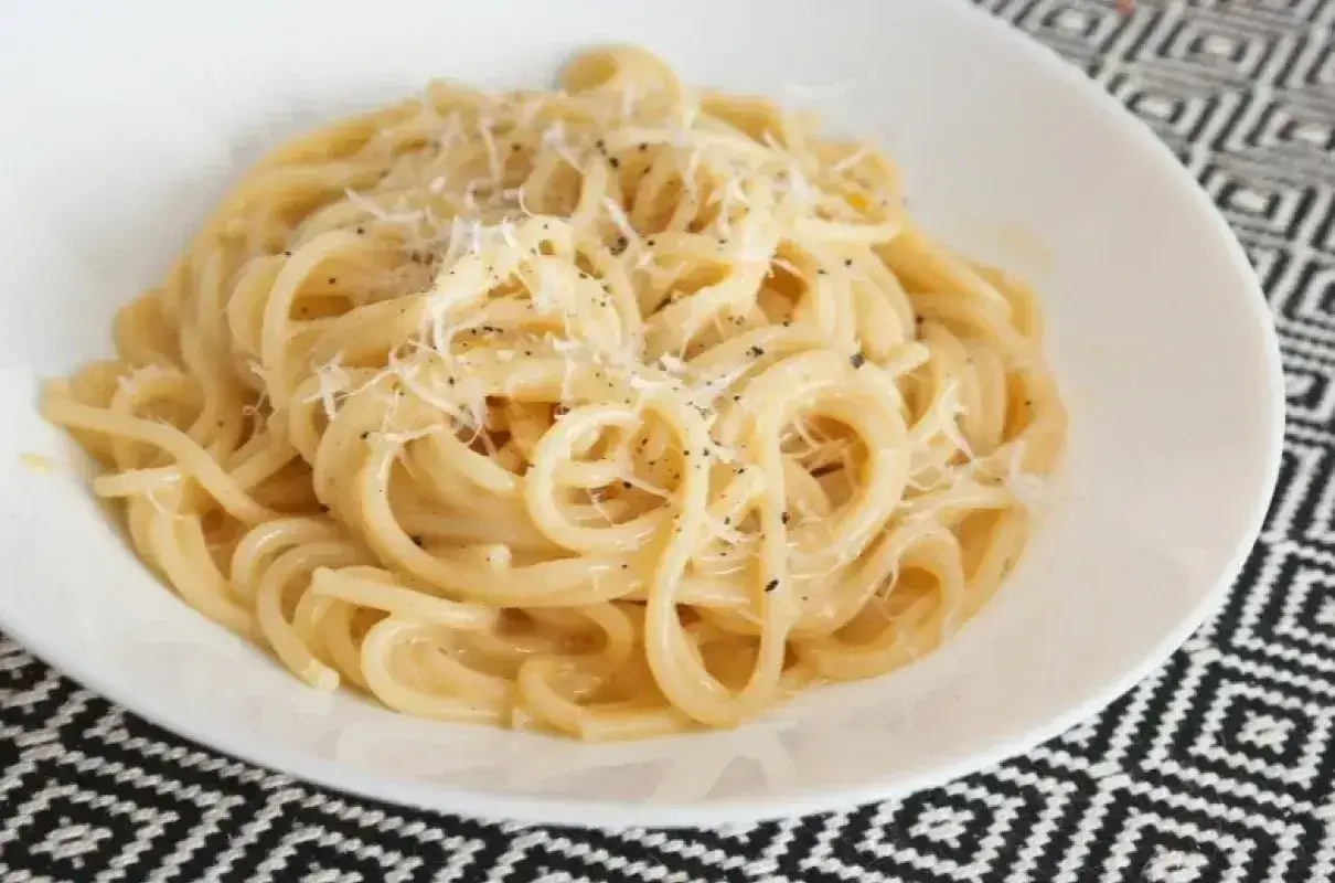 Kremowe spaghetti carbonara, posypane parmezanem i pieprzem. Prosty przepis na pyszny obiad.