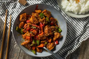 Aromaticzny kurczak po seczuańsku z papryką i sezamem, podany z ryżem.