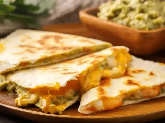 Pyszna, lekka kolacja: quesadillas z roztopionym serem i guacamole. Idealne na szybki posiłek.